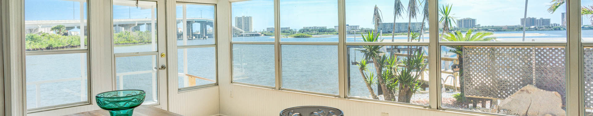 Photo of the view of the blue ocean and bridge over the water from inside a manufactured home through glass windows
