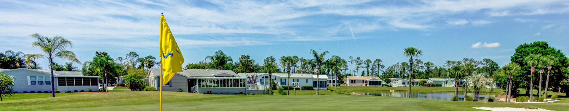 Photo of the lush green golf field surrounded by the community of mobile homes, with nice green trees